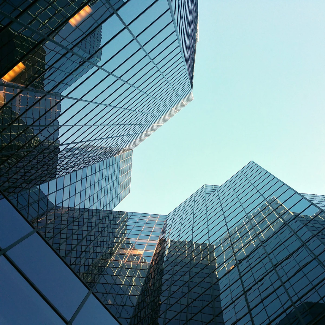 Glass skyscrapers photographed from below: the corporate structure that sustains growth