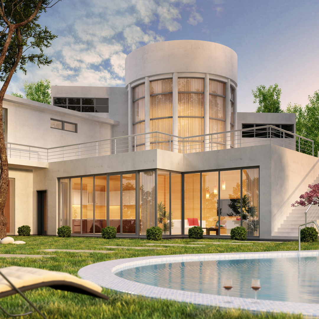Contemporary villa with a central tower and large glass walls, swimming pool in the foreground at sunset